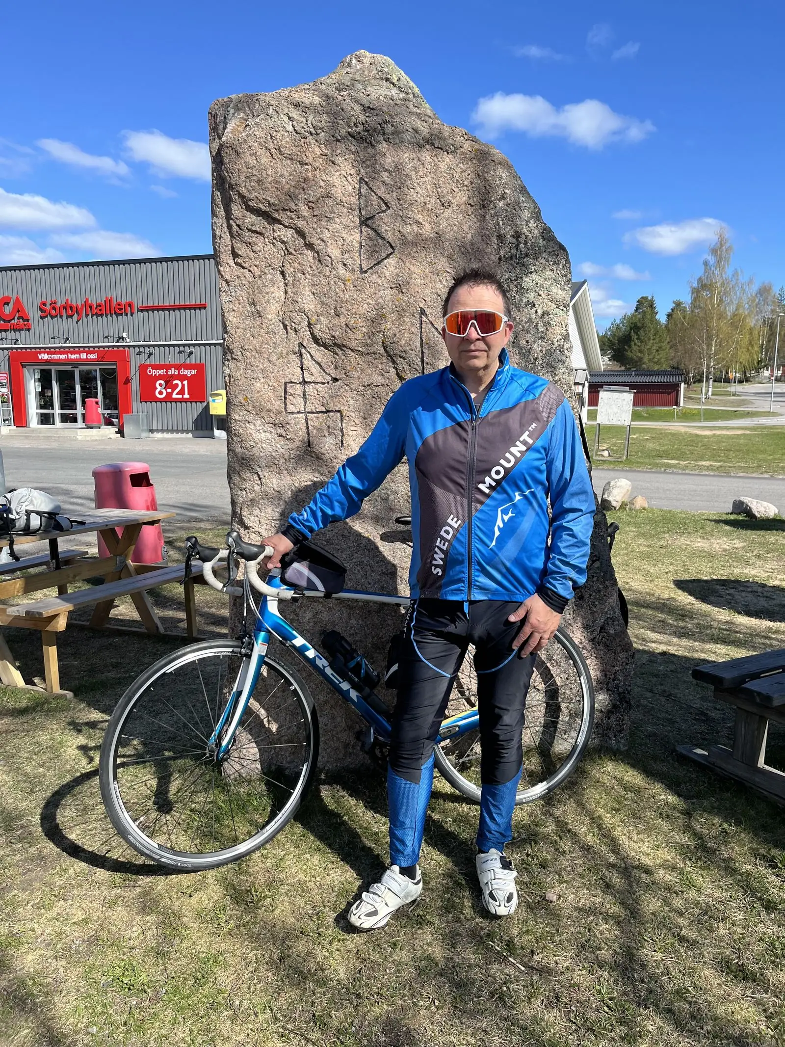 Föreläsaren med racercykel vid en runsten